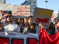 Demonstrators raise a placard that reads in Arabic, ''O Pharaoh, you who transgress the law,'' during a demonstration organized by the Tunis...