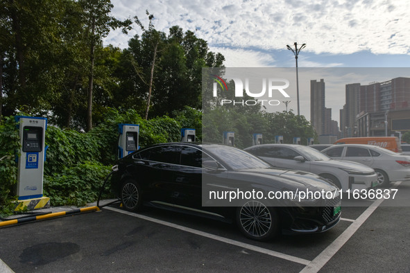 Electric vehicles charge at an electric vehicle charging station on a street in Fuyang, China, on October 5, 2024. 