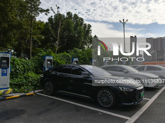 Electric vehicles charge at an electric vehicle charging station on a street in Fuyang, China, on October 5, 2024. (