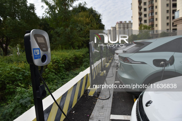 Electric vehicles charge at an electric vehicle charging station on a street in Fuyang, China, on October 5, 2024. 