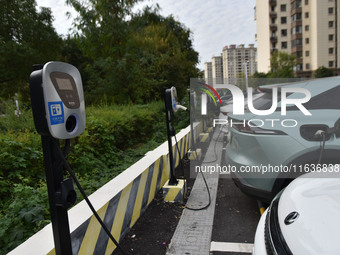 Electric vehicles charge at an electric vehicle charging station on a street in Fuyang, China, on October 5, 2024. (