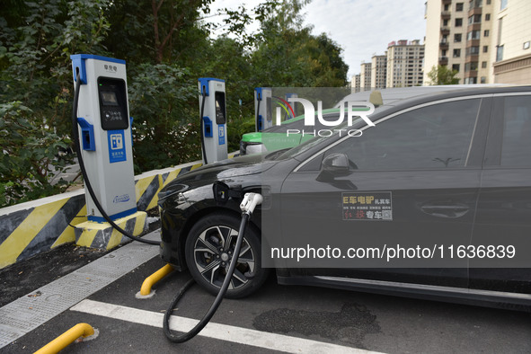 Electric vehicles charge at an electric vehicle charging station on a street in Fuyang, China, on October 5, 2024. 