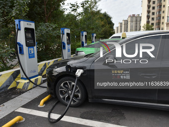 Electric vehicles charge at an electric vehicle charging station on a street in Fuyang, China, on October 5, 2024. (