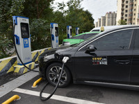 Electric vehicles charge at an electric vehicle charging station on a street in Fuyang, China, on October 5, 2024. (