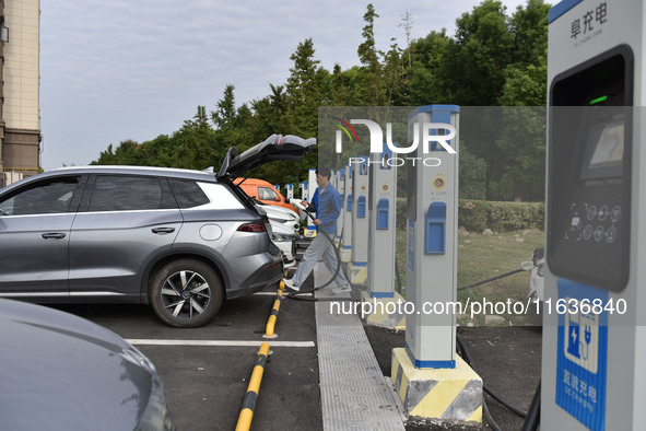 Electric vehicles charge at an electric vehicle charging station on a street in Fuyang, China, on October 5, 2024. 