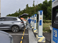 Electric vehicles charge at an electric vehicle charging station on a street in Fuyang, China, on October 5, 2024. (