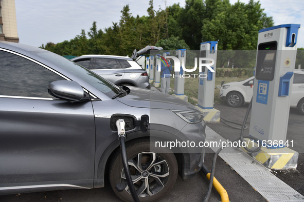 Electric vehicles charge at an electric vehicle charging station on a street in Fuyang, China, on October 5, 2024. 