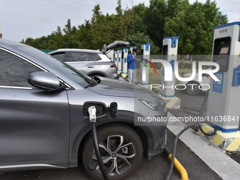 Electric vehicles charge at an electric vehicle charging station on a street in Fuyang, China, on October 5, 2024. (