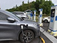 Electric vehicles charge at an electric vehicle charging station on a street in Fuyang, China, on October 5, 2024. (