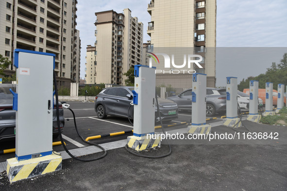 Electric vehicles charge at an electric vehicle charging station on a street in Fuyang, China, on October 5, 2024. 