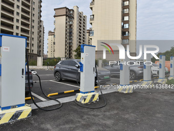 Electric vehicles charge at an electric vehicle charging station on a street in Fuyang, China, on October 5, 2024. (