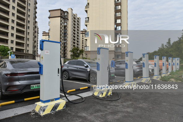 Electric vehicles charge at an electric vehicle charging station on a street in Fuyang, China, on October 5, 2024. 