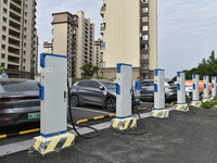 Electric vehicles charge at an electric vehicle charging station on a street in Fuyang, China, on October 5, 2024. (