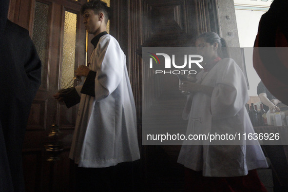 Devotees raise their pets to receive holy water blessings during a mass to bless pets and animals as part of 'World Animal Day' at Iglesia d...