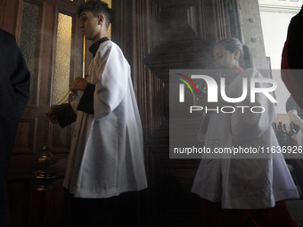 Devotees raise their pets to receive holy water blessings during a mass to bless pets and animals as part of 'World Animal Day' at Iglesia d...