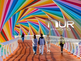 Tourists visit the Rainbow Bridge by Tangdao Bay in the West Coast New Area of Qingdao, East China's Shandong province, on October 5, 2024....