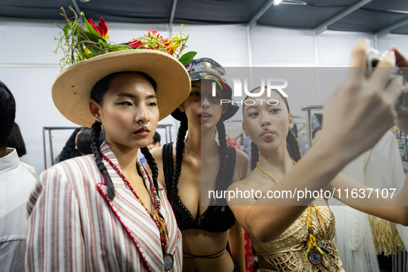 Models wear creations by ISSUE and get ready backstage before walking on the runway during Day 3 of Bangkok International Fashion Week at Si...