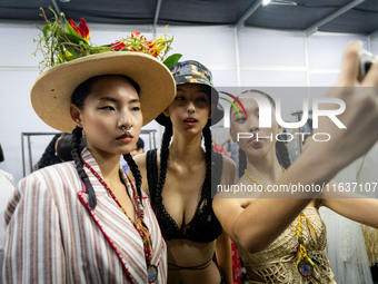 Models wear creations by ISSUE and get ready backstage before walking on the runway during Day 3 of Bangkok International Fashion Week at Si...