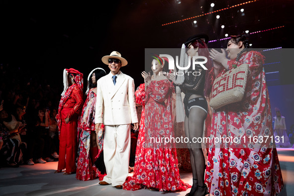 Models stand with Bhubawit 'Roj' Kritpholnara, designer of ISSUE, on the runway on Day 3 of Bangkok International Fashion Week at Siam Parag...