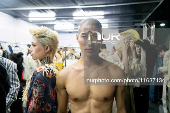 Models wear creations by POEM and get ready backstage before walking on the runway during Day 3 of Bangkok International Fashion Week at Sia...