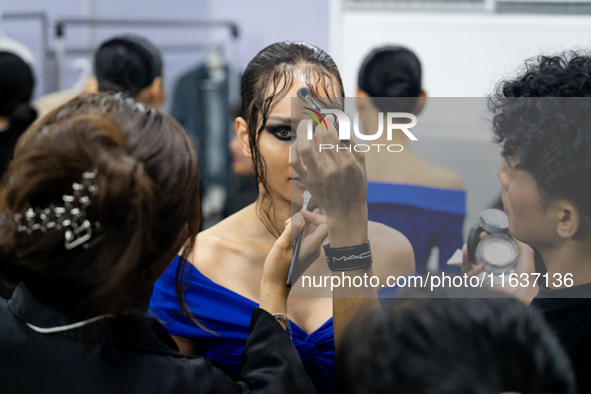 Models wear creations by POEM and get ready backstage before walking on the runway during Day 3 of Bangkok International Fashion Week at Sia...