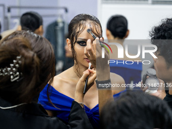 Models wear creations by POEM and get ready backstage before walking on the runway during Day 3 of Bangkok International Fashion Week at Sia...