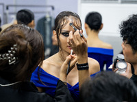 Models wear creations by POEM and get ready backstage before walking on the runway during Day 3 of Bangkok International Fashion Week at Sia...