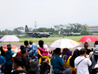 A number of residents watch aircraft landing during the TNI Transport Aircraft Static Show event to commemorate the 79th Anniversary of the...