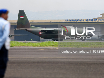 A soldier watches a plane land during the TNI Transport Aircraft Static Show event to commemorate the 79th Anniversary of the TNI at Husein...