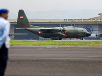 A soldier watches a plane land during the TNI Transport Aircraft Static Show event to commemorate the 79th Anniversary of the TNI at Husein...