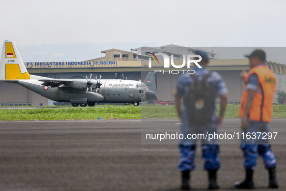 A number of soldiers watch aircraft landing during the TNI Transport Aircraft Static Show event to commemorate the 79th Anniversary of the T...