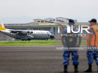 A number of soldiers watch aircraft landing during the TNI Transport Aircraft Static Show event to commemorate the 79th Anniversary of the T...