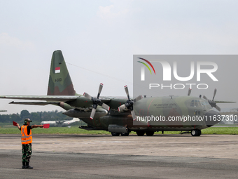 Aircraft land during the TNI Transport Aircraft Static Show event to commemorate the 79th Anniversary of the TNI at Husein Sastranegara Air...