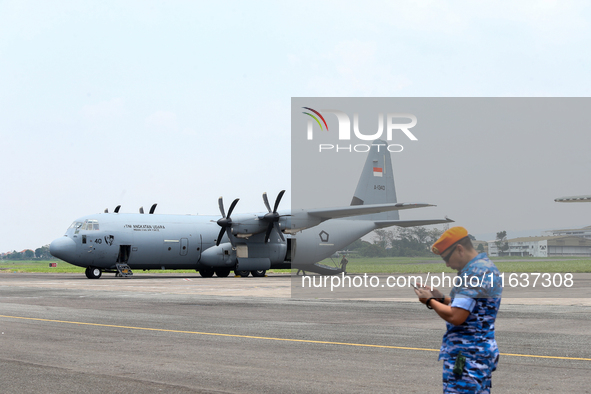 Aircraft land during the TNI Transport Aircraft Static Show event to commemorate the 79th Anniversary of the TNI at Husein Sastranegara Air...