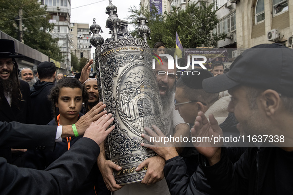 Ultra-Orthodox Jewish pilgrims carry the Torah near the tomb of Rabbi Nachman while celebrating Rosh Hashanah, the Jewish New Year, amid the...