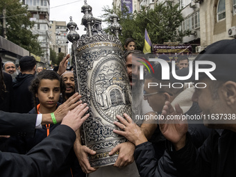 Ultra-Orthodox Jewish pilgrims carry the Torah near the tomb of Rabbi Nachman while celebrating Rosh Hashanah, the Jewish New Year, amid the...