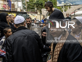 Ultra-Orthodox Jewish pilgrims carry the Torah near the tomb of Rabbi Nachman while celebrating Rosh Hashanah, the Jewish New Year, amid the...