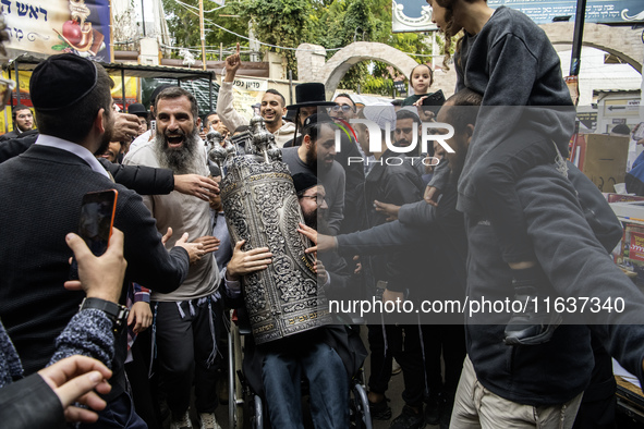 Ultra-Orthodox Jewish pilgrims carry the Torah near the tomb of Rabbi Nachman while celebrating Rosh Hashanah, the Jewish New Year, amid the...