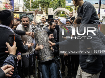 Ultra-Orthodox Jewish pilgrims carry the Torah near the tomb of Rabbi Nachman while celebrating Rosh Hashanah, the Jewish New Year, amid the...