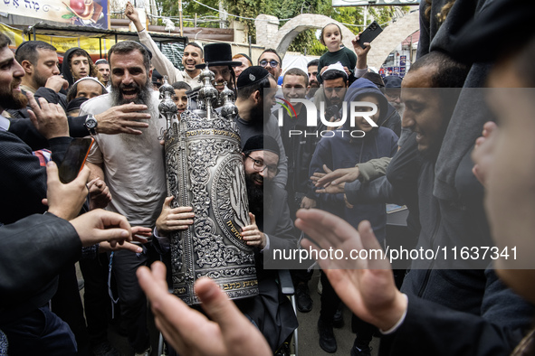 Ultra-Orthodox Jewish pilgrims carry the Torah near the tomb of Rabbi Nachman while celebrating Rosh Hashanah, the Jewish New Year, amid the...