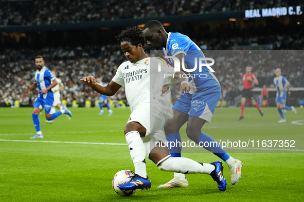 Endrick centre-forward of Real Madrid and Brazil and Moussa Diarra centre-back of Alaves and Mali compete for the ball during the La Liga ma...