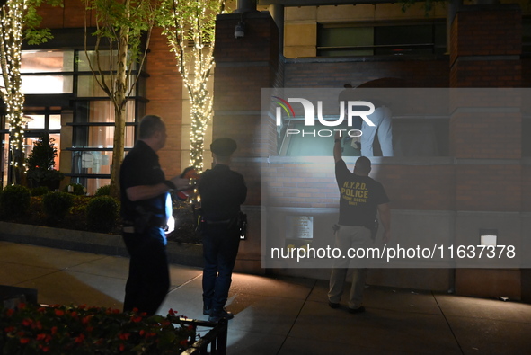 New York City Police Department crime scene investigators swab for evidence outside the One Carnegie Hill luxury rental apartment complex lo...