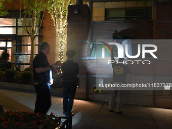 New York City Police Department crime scene investigators swab for evidence outside the One Carnegie Hill luxury rental apartment complex lo...