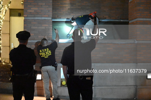 New York City Police Department crime scene investigators swab for evidence outside the One Carnegie Hill luxury rental apartment complex lo...