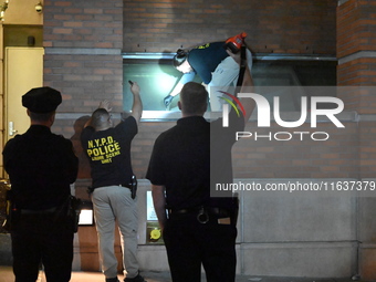 New York City Police Department crime scene investigators swab for evidence outside the One Carnegie Hill luxury rental apartment complex lo...