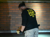 New York City Police Department crime scene investigators swab for evidence outside the One Carnegie Hill luxury rental apartment complex lo...