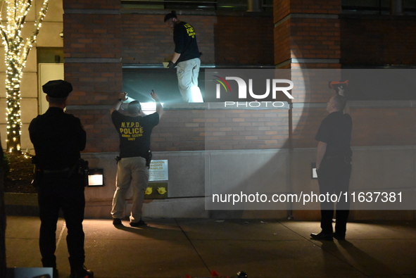 New York City Police Department crime scene investigators swab for evidence outside the One Carnegie Hill luxury rental apartment complex lo...