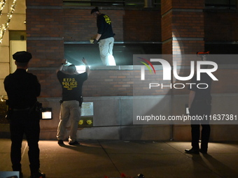 New York City Police Department crime scene investigators swab for evidence outside the One Carnegie Hill luxury rental apartment complex lo...