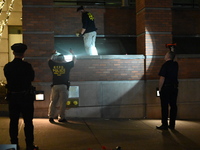 New York City Police Department crime scene investigators swab for evidence outside the One Carnegie Hill luxury rental apartment complex lo...