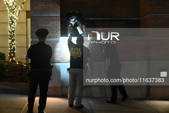 New York City Police Department crime scene investigators swab for evidence outside the One Carnegie Hill luxury rental apartment complex lo...